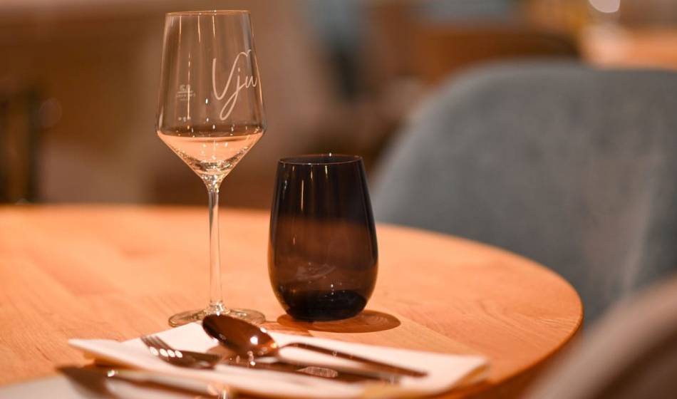 Table setting at the Strandläufer restaurant on Rügen with a wine glass, water glass and cutlery ready for guests.