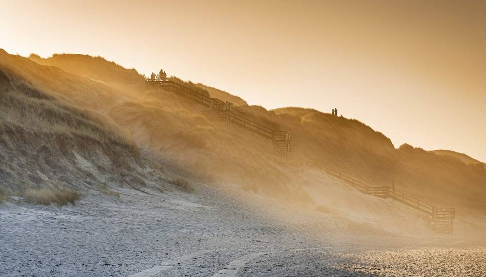 Himmelstreppe in Westerland auf Sylt bei stürmischem Wetter und warmem Abendlicht über den Dünen