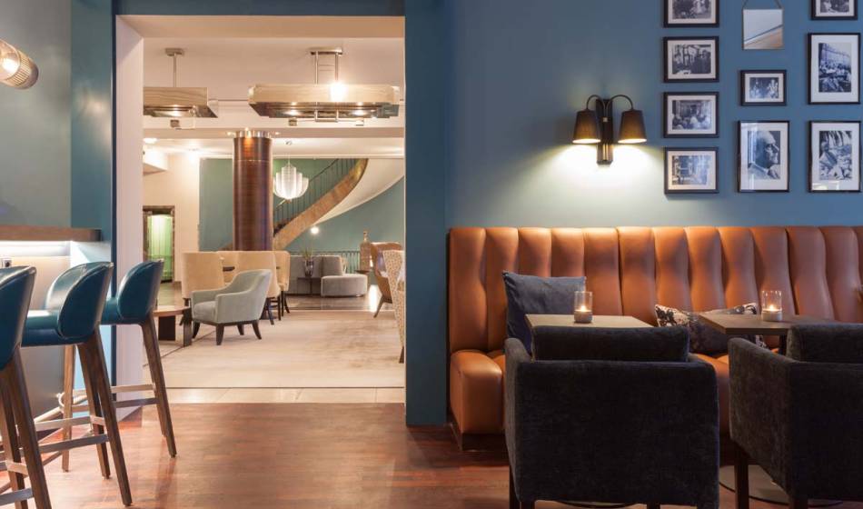 Stylish seating area in the bar of the Hotel Elephant Weimar with upholstered leather sofas and cozy lighting.
