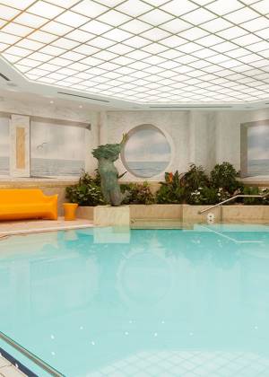 Großer, eleganter Innenpool im Wellnessbereich des Hotel Kaiserhof Heringsdorf mit mediterranem Flair.