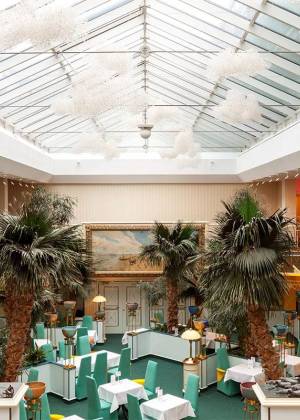 Palmengarten im Hotel Kaiserhof Heringsdorf mit Palmen, Sitzbereichen und Glasdach in heller Atmosphäre.