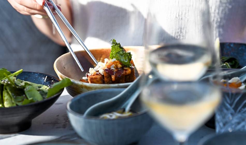 Close-up of lunch at #herrhoshi with fresh side dishes in rustic bowls with chopsticks in the background.