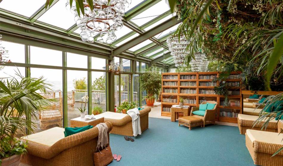 Relaxation room in the Kaiserhof Heringsdorf on Usedom with comfortable loungers, lots of daylight and a view of the terrace.