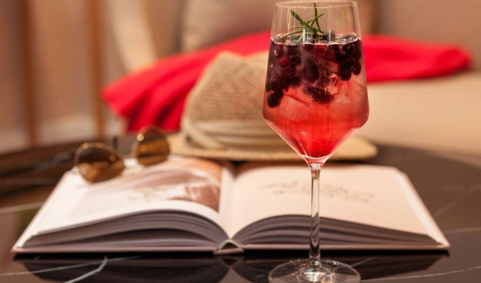 Fruity cocktail with a sprig of rosemary, served in the living room lounge for a holiday feeling at the Vju Hotel on Rügen.