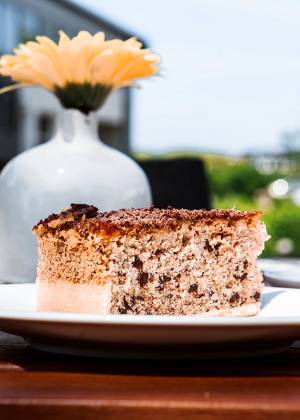 Stück Kuchen mit Kaffee und einer Blumenvase auf einem Tisch im Café #fraukorn.