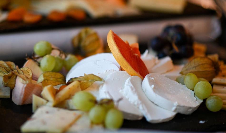 Selection of cheeses for breakfast at the Vju Hotel Rügen, served with grapes and grapefruit during your gourmet holiday.