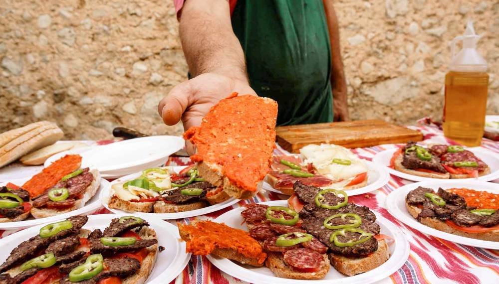 Frisches Pan mit Sobrasada, Tomaten und Peperoni, auf einem Markttisch serviert, typisch für Mallorca