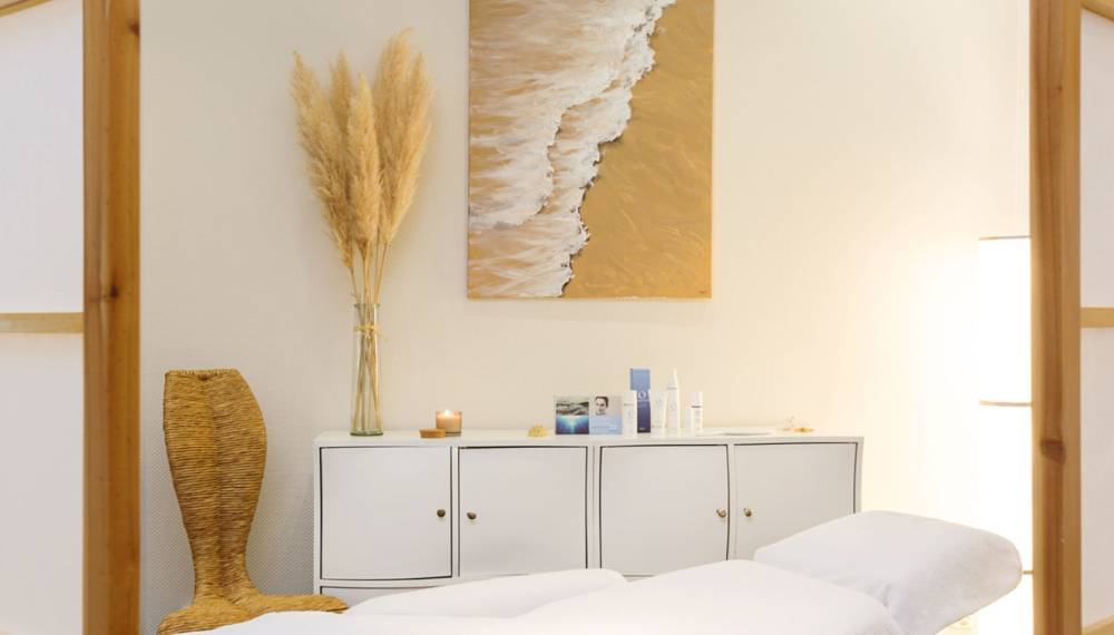 Wellnesszimmer im Hotel Kaiserhof Heringsdorf auf Usedom, ausgestattet mit Hautpflegeprodukten von Oceanwell und einer Spa-Liege.