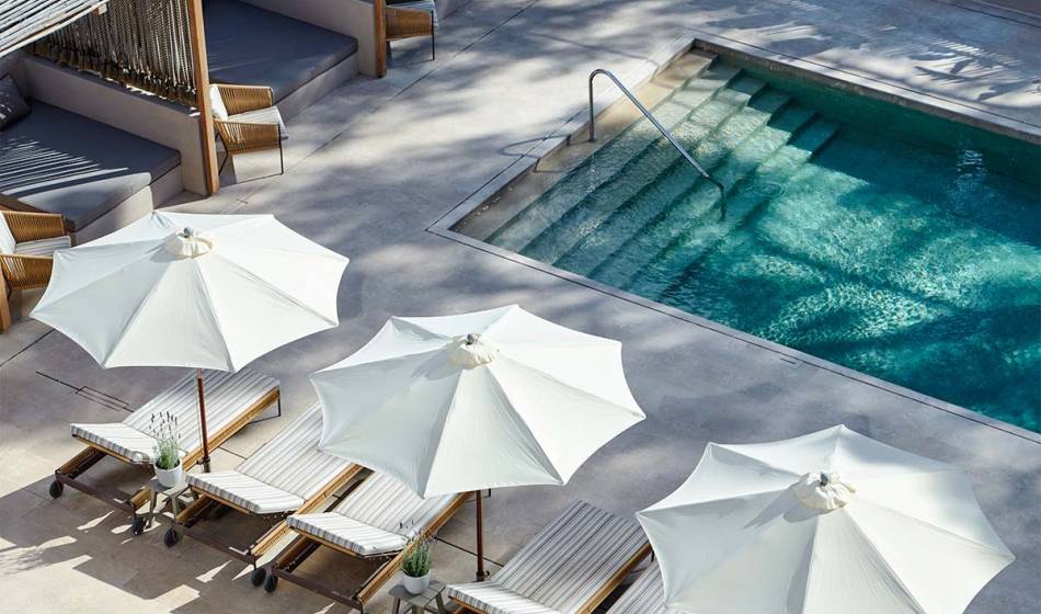 Modern pool area with shaded loungers and large white parasols at the Barefoot Hotel Mallorca.