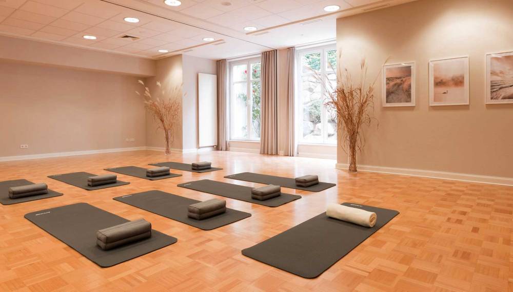 Matten liegen bereit für einen Kurs im hellen Yogastudio des Vju Hotels Rügen.
