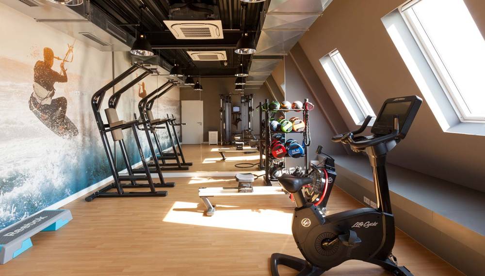 Moderner Fitnessraum im Wyn. Strandhotel Sylt, mit Laufbändern, Fahrrädern und Kraftgeräten für Gäste
