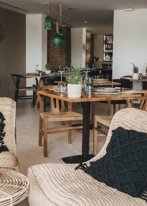 Essbereich mit Stühlen, gemütlichen Sesseln und gedeckten Tischen im Barefoot Restaurant des Barefoot Hotels auf Mallorca.