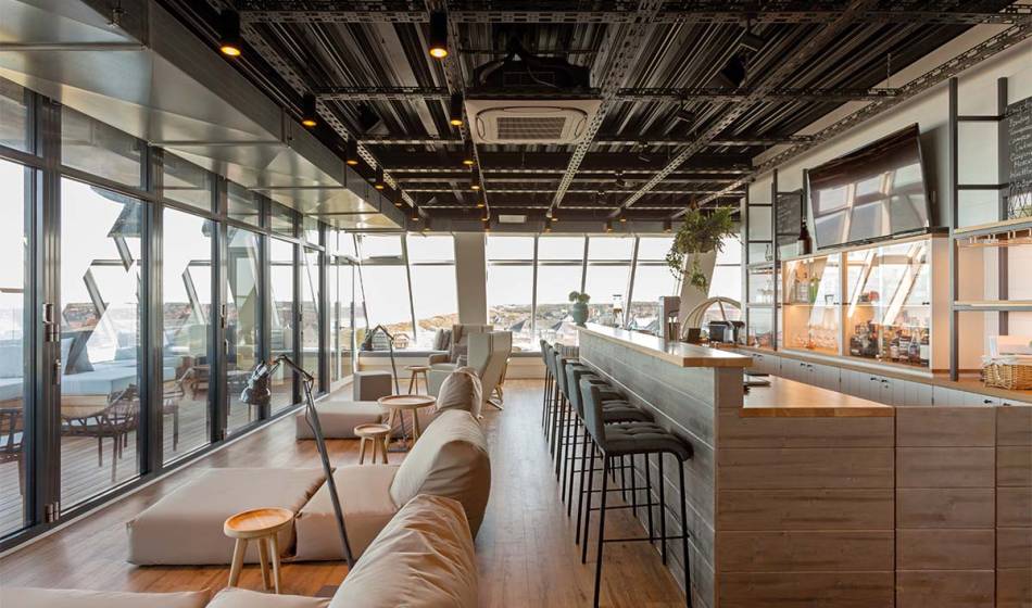 Moderne Bar mit entspanntem Ambiente, großen Fenstern und einem Panoramablick auf die Nordsee im Wyn. Strandhotel.
