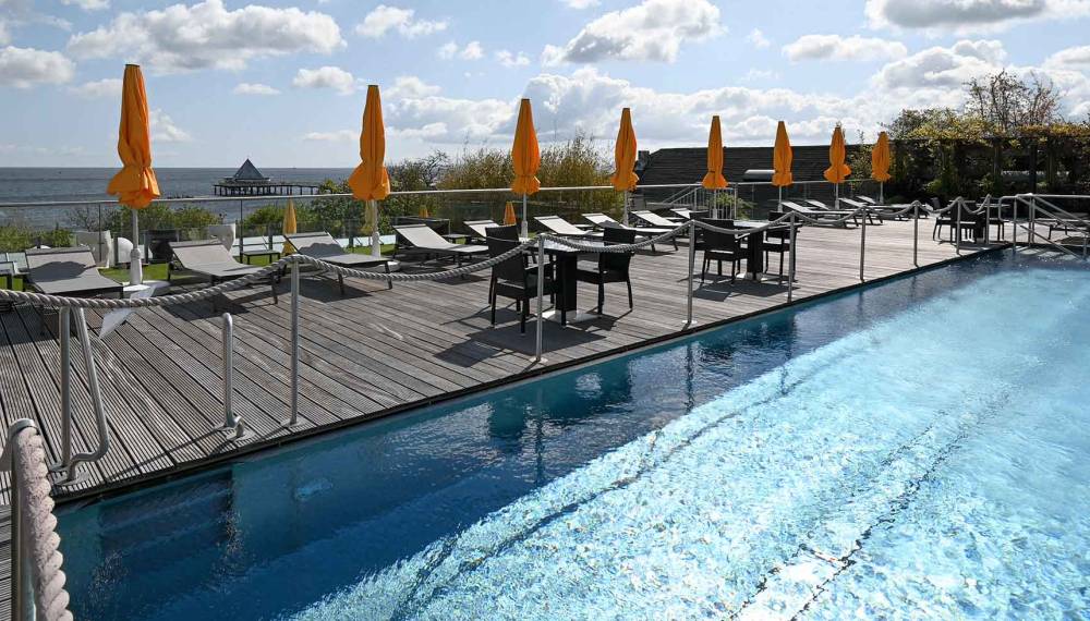 Nahaufnahme des Außenpool auf dem Dach des Hotels Kaiserhof Heringsdorf mit Blick auf die Ostsee und die Seebrücke.