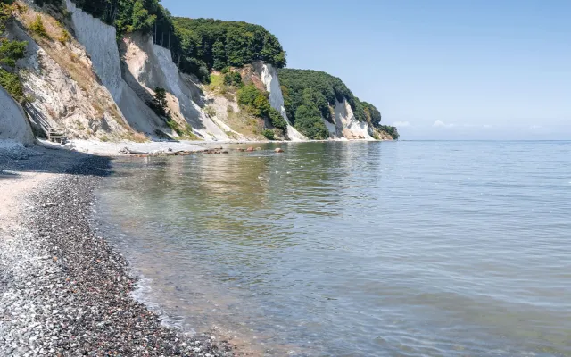 Kreidefelsen auf Rügen mit ruhigem Meer und klarem Himmel.