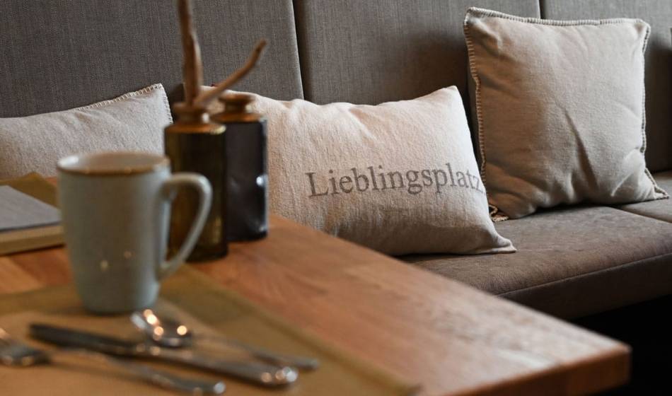 Cozy seating area in the Vju Hotel Rügen with decorative cushions for culinary enjoyment on your Baltic Sea vacation.