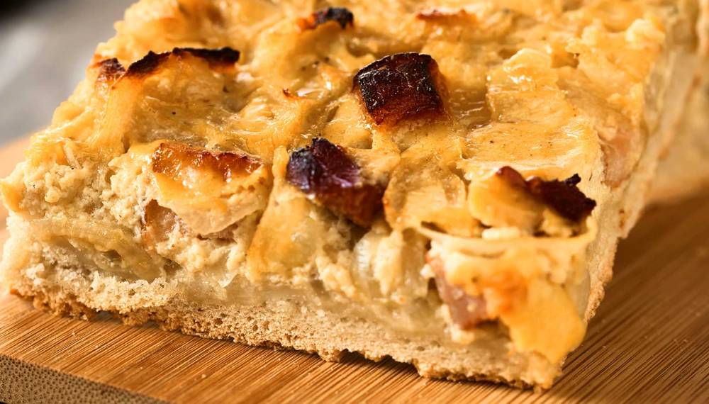 Zwei Stücke Zwiebelkuchen auf einem Brett.