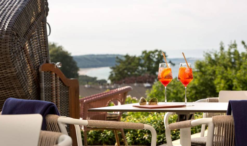 Two Aperol spritzes on a terrace table next to a beach chair on the Seeblick-Terrasse at the Vju Hotel on Rügen.
