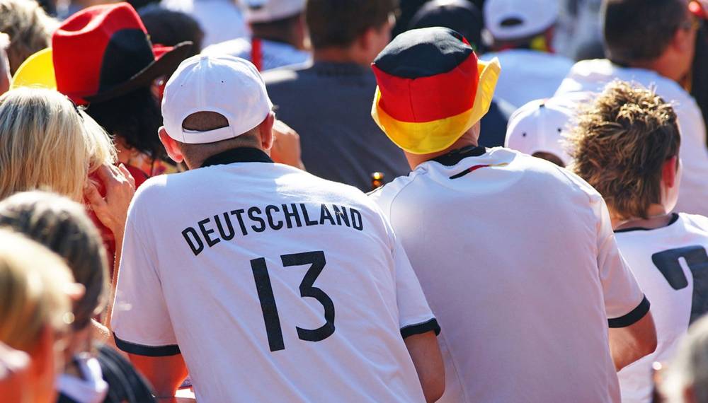 Fußballfans beim Public Viewing auf Usedom in Deutschland Trikots mit Fahnen und begeisterter Stimmung.