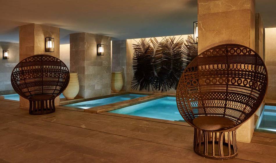 Wellness area with heated indoor pool, modern lighting elements and comfortable seating in the Barefoot Hotel.