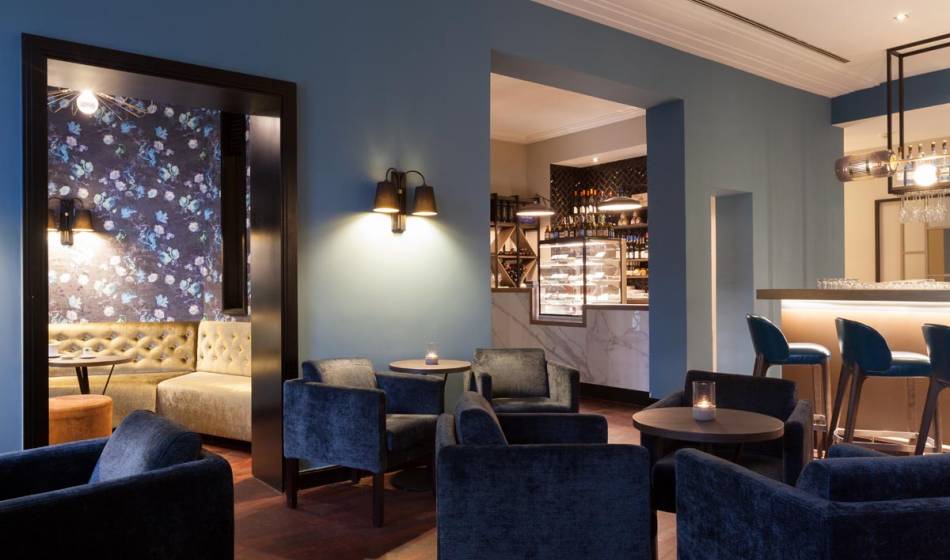 Stylish bar in the Hotel Elephant Weimar with various lounge areas and modern, blue decoration.