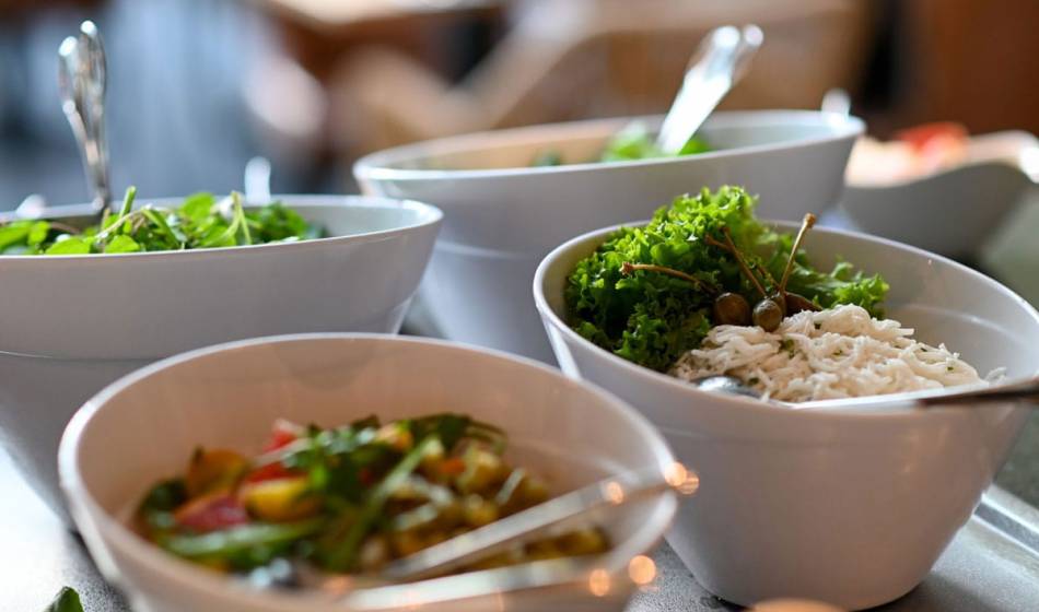 Selection of side dishes in bowls, including salad, herbs and fine ingredients, served at the Strandläufer restaurant on Rügen.