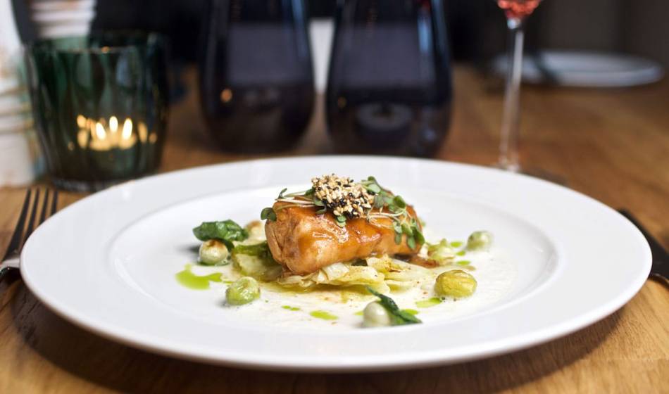 Finely prepared Rügen-style fish dish, with vegetables and herbs, stylishly presented at the Strandläufer restaurant.