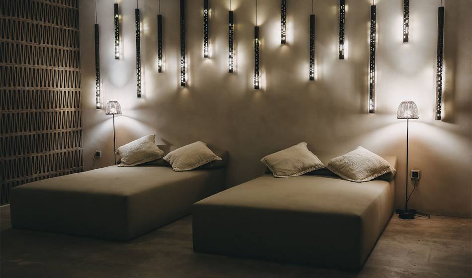 Two large loungers in the wellness relaxation area of ​​the Barefoot Hotel, with warm light accents on the wall.
