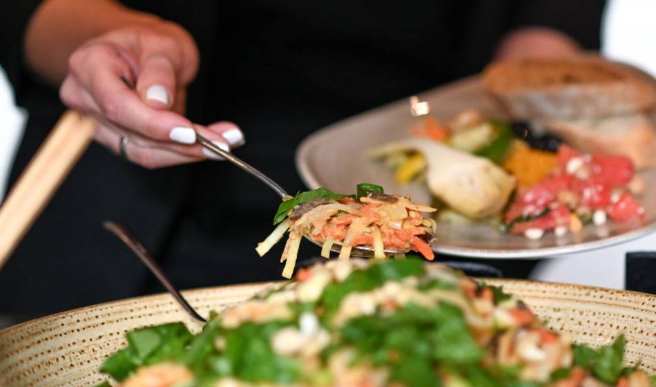 Fresh, colorful salad with crunchy vegetables and herbs stylishly arranged in a large bowl in the Strandläufer restaurant.