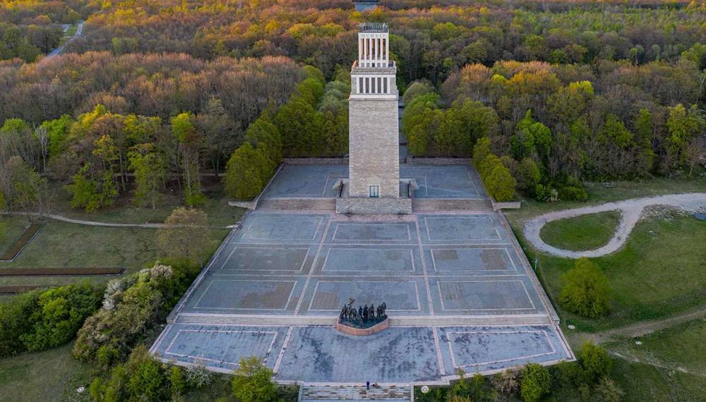 Gedenkstätte Buchenwald bei Weimar mit dem markanten Glockenturm und dem weitläufigen Appellplatz, umgeben von Wald.