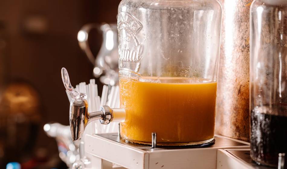 Glass carafe with fresh orange juice and tap in the breakfast area of ​​#fraukorn in the Seezeichen artist quarter.