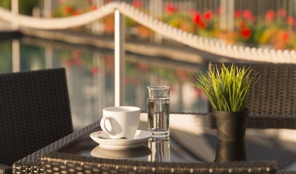 Coffee cup and glass of water in the summer garden at Kaiserhof Heringsdorf on Usedom.
