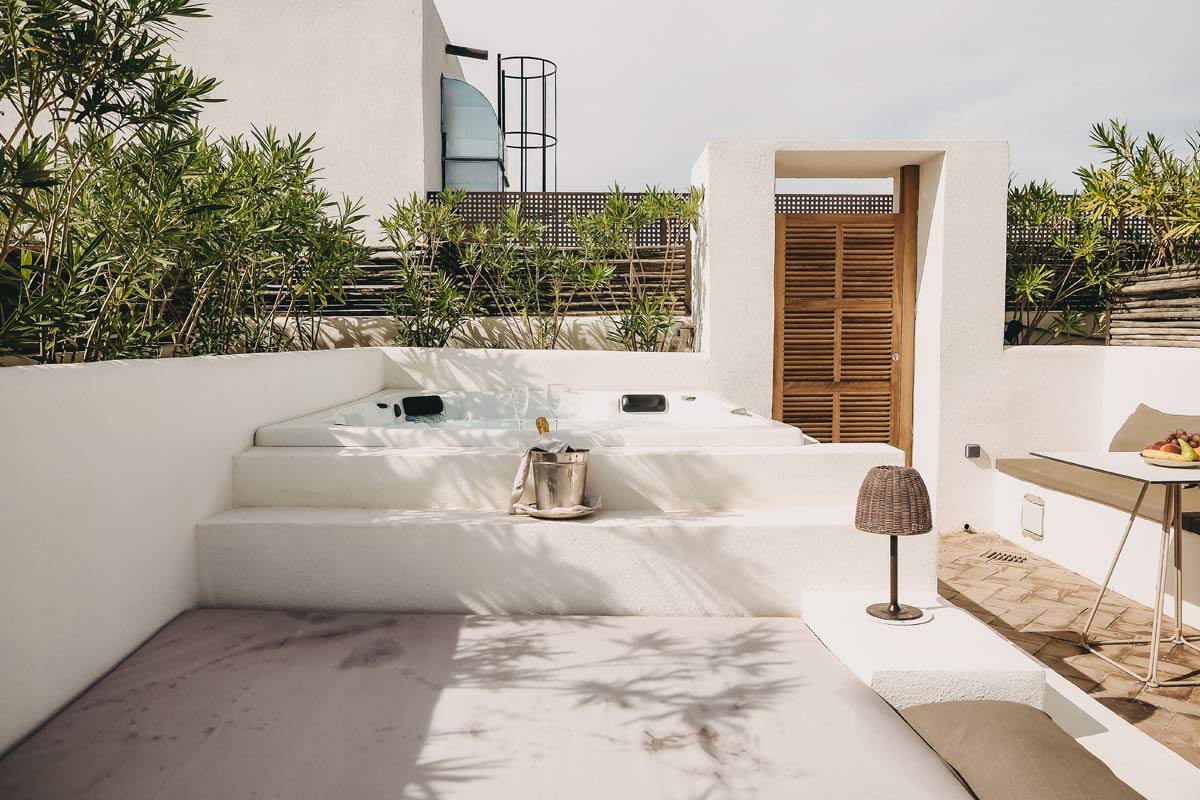 Private terrace of the Pequeña Suite with whirlpool, seating area and Mediterranean atmosphere at the Barefoot Hotel Mallorca.