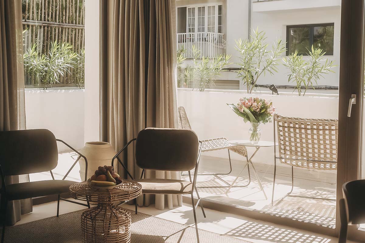 Private terrace of the Patio suite in the Barefoot Hotel with cozy seating, plants and stylish furnishings.