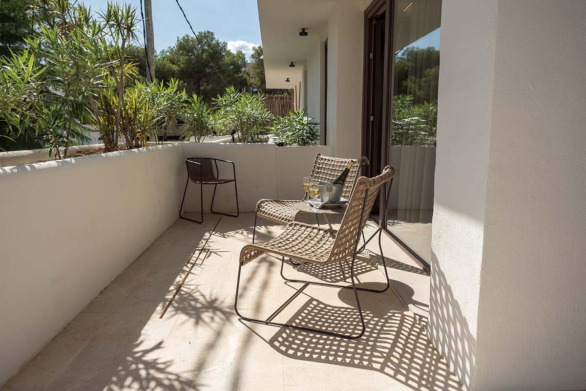 Sunny terrace of the Patio suite in the Barefoot Hotel on Mallorca with elegant furniture and views of plants.