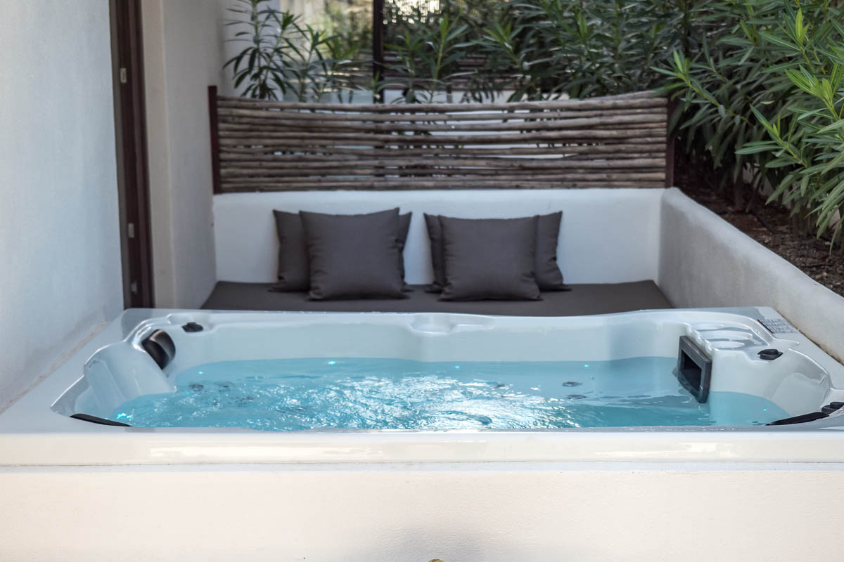 Private whirlpool on the terrace of the Patio suite at the Barefoot Hotel Mallorca with cushions and surrounded by plants