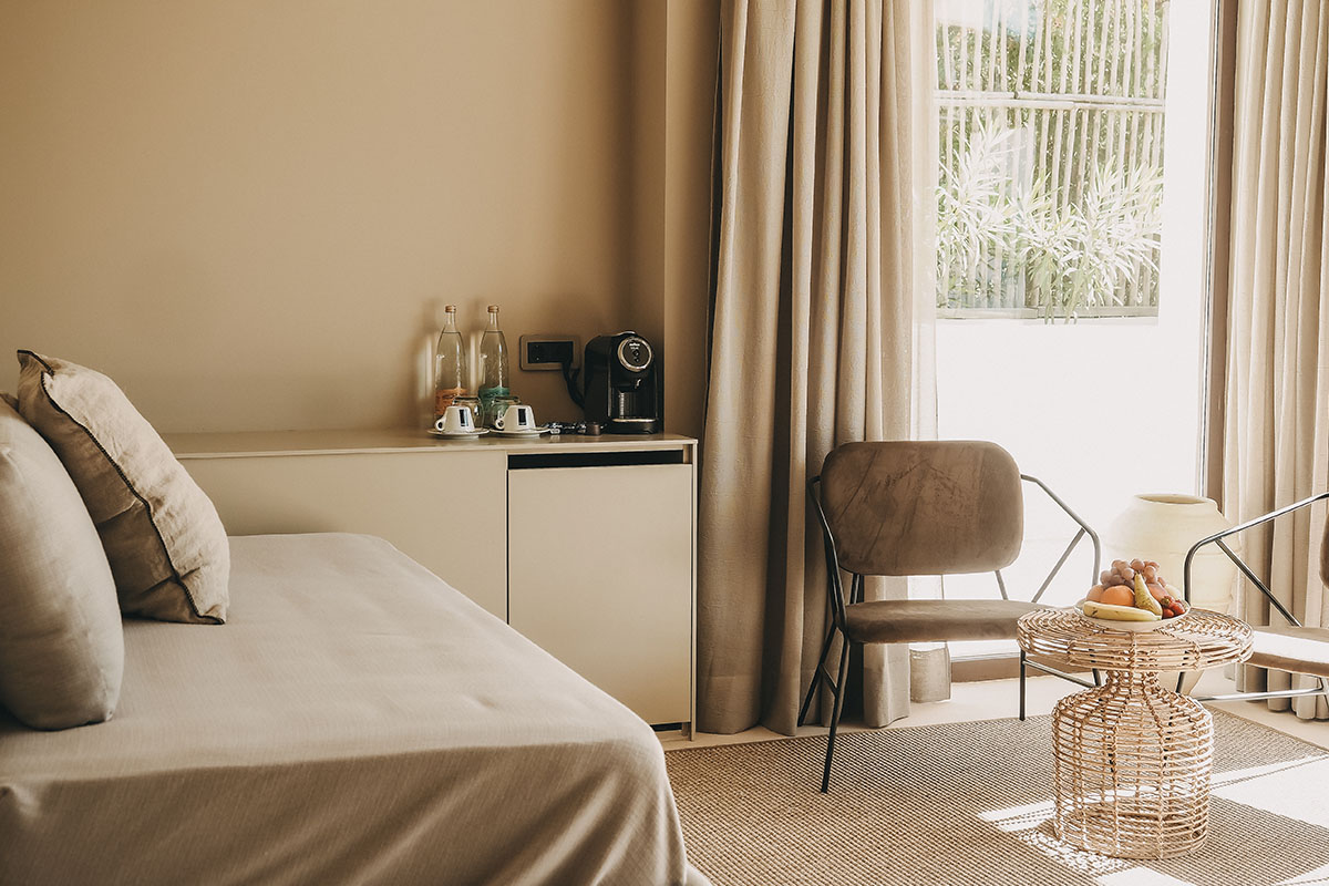 Cozy living area in the Patio suite of the Barefoot Hotel on Mallorca with seating furniture, table and view of the greenery