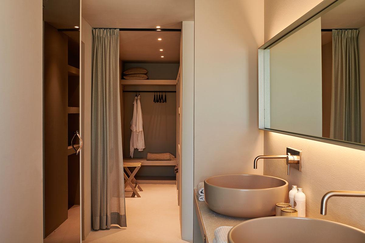 Elegant dressing room with curtain and stylish bathroom with double washbasin in the suite of the Barefoot Hotel on Mallorca.