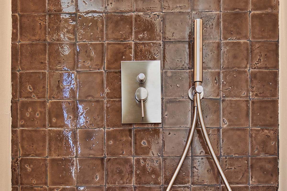 Close-up of an elegant shower with brown ceramic tiles and modern fittings in the Barefoot Hotel on Mallorca.