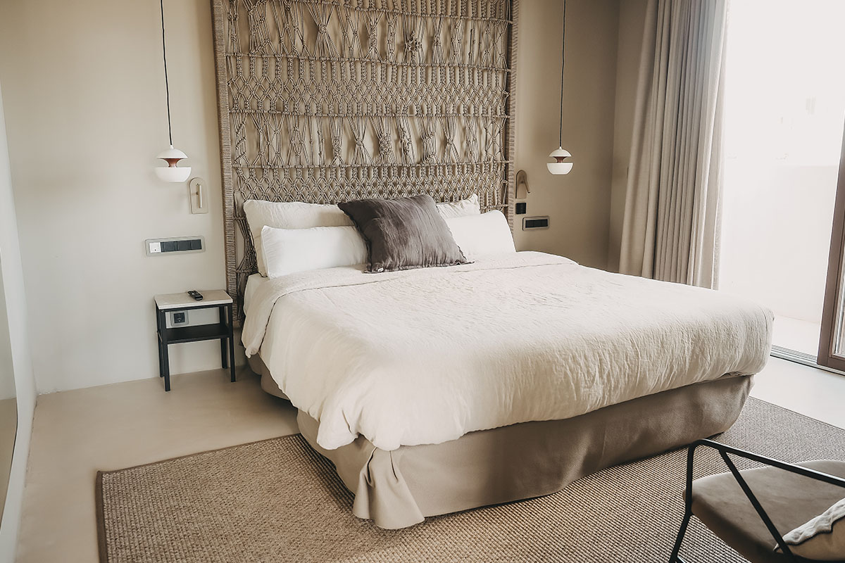 Sleeping area of the suite in the Barefoot Hotel Mallorca with modern design, cozy bed and stylish wall design.