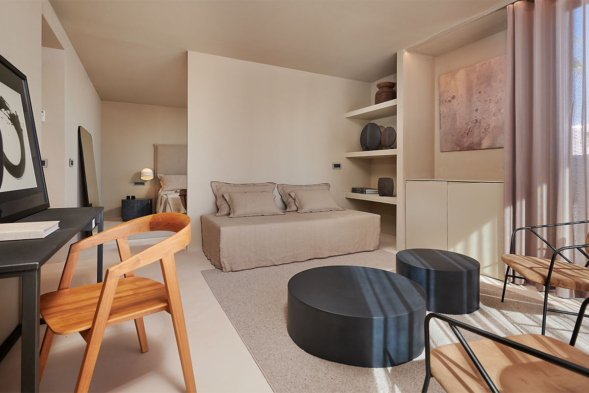 Modern living area of the suite in the Barefoot Hotel on Mallorca with sofa, wooden chair and stylish details.