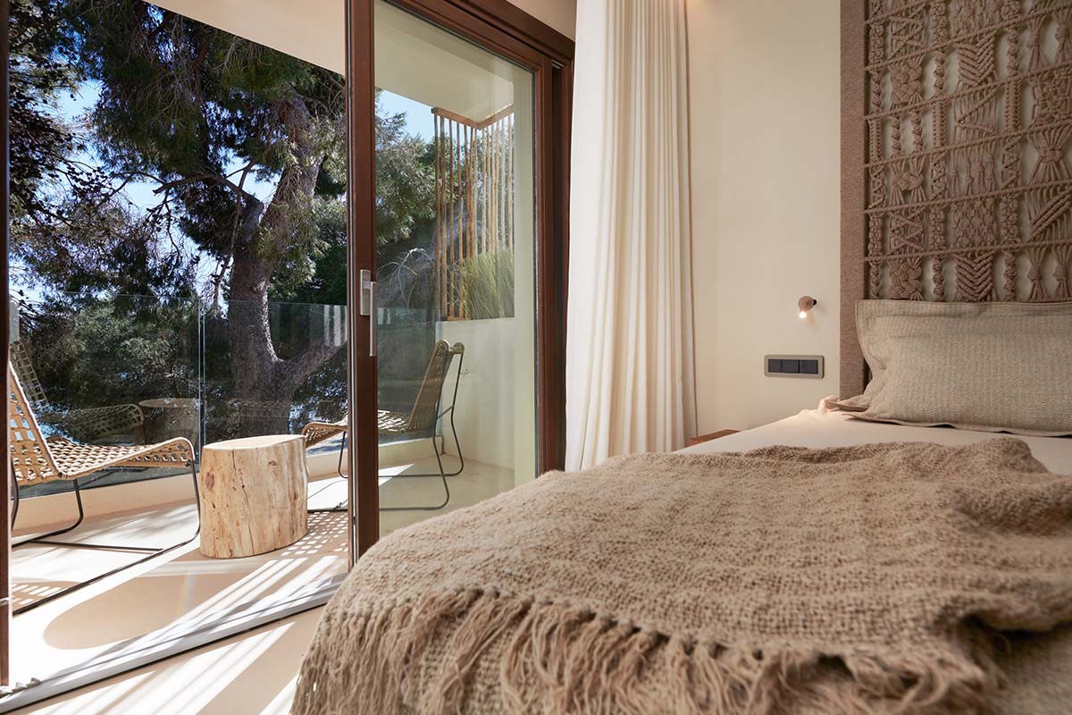 Double room Mar at the Barefoot Hotel on Mallorca with stylish bed, access to the terrace and views of nature.
