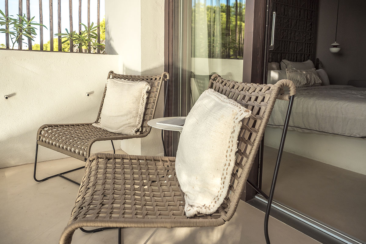 rivate balcony in the double room Mar of the Barefoot Hotel Mallorca with two stylish chairs, cushions and a small table.