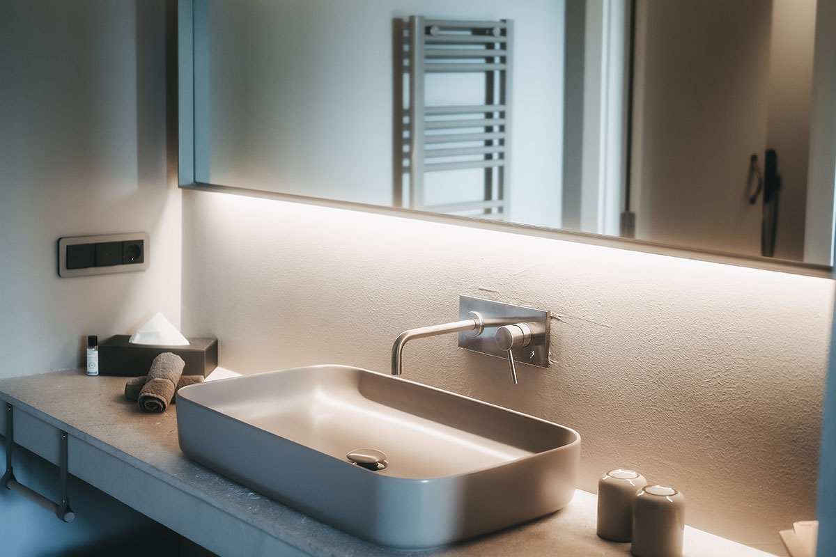 Washbasin in the Oasis double room at the Barefoot Hotel on Mallorca with a modern design, large mirror and elegant lighting.