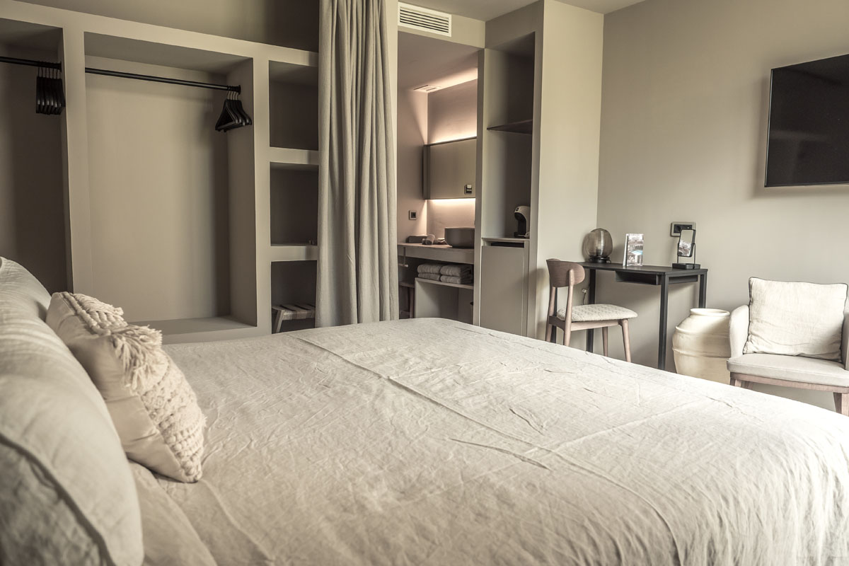 Cozy Puro hotel room in boho style with large bed, open furnishings and desk in the Barefoot Hotel.