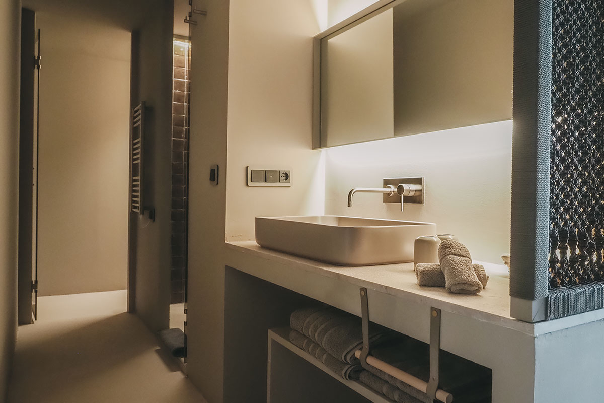 Modern bathroom in the Pino room at the Barefoot Hotel Mallorca with designer washbasin and atmospheric lighting.