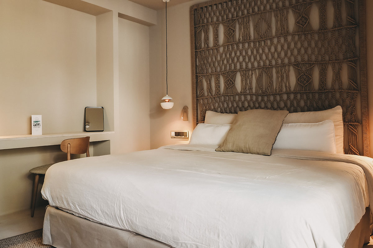 Comfortable bed in the Pino room at the Barefoot Hotel Mallorca with decorative headboard and pillows.