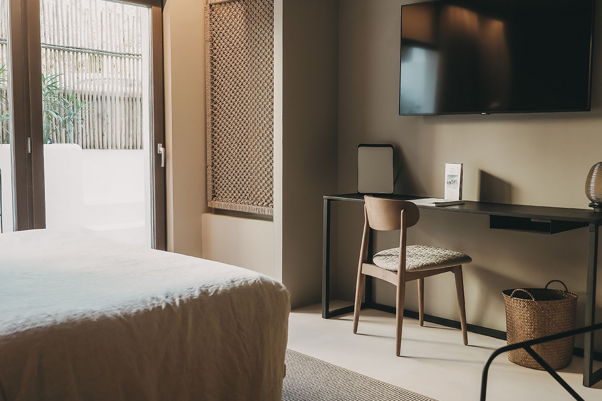 Modern work area in the Pueblo room of the Barefoot Hotel Mallorca with desk and wooden chair.