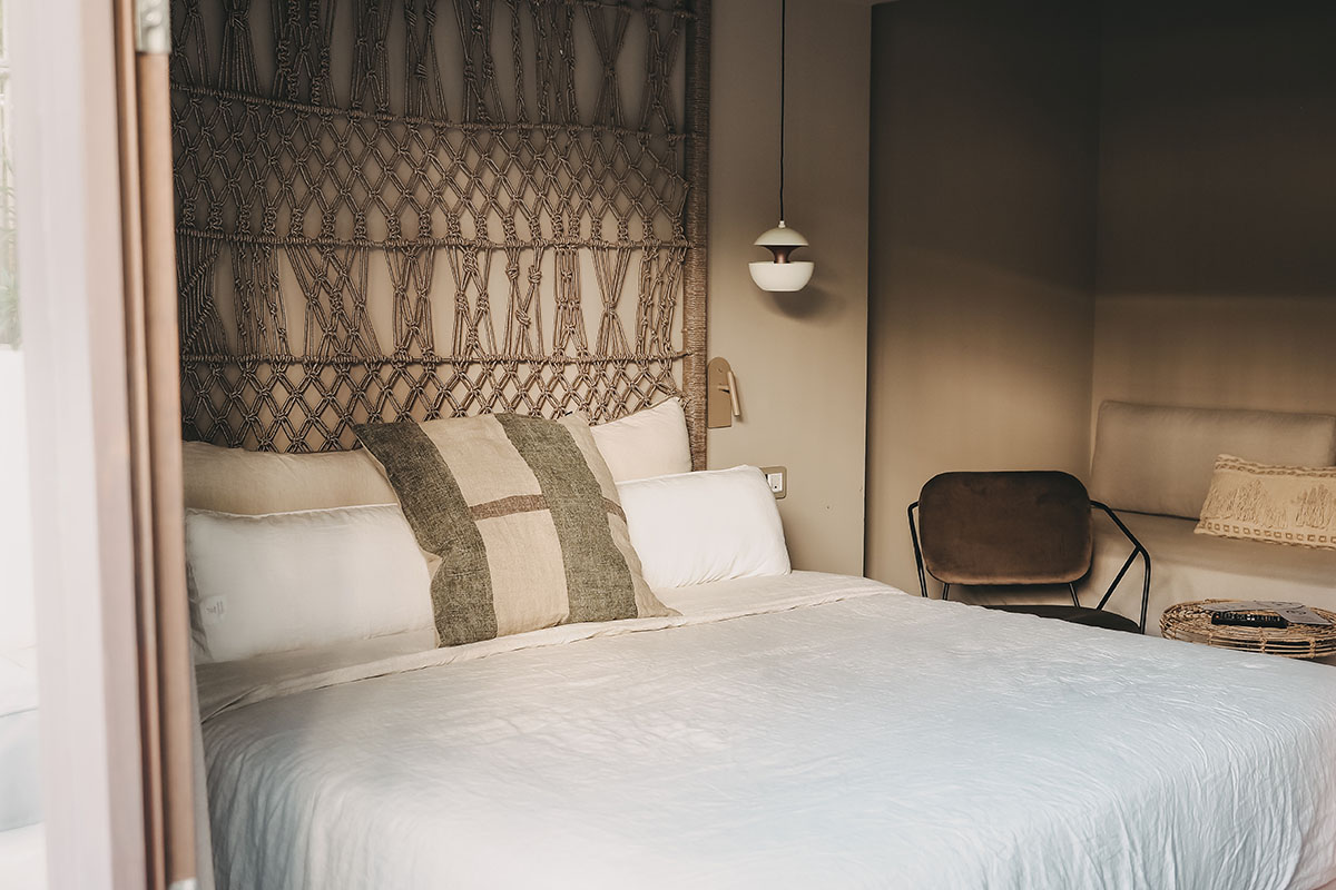 Cozy sleeping area in the Pueblo room of the Barefoot Hotel Mallorca with decorative headboard and pillows.
