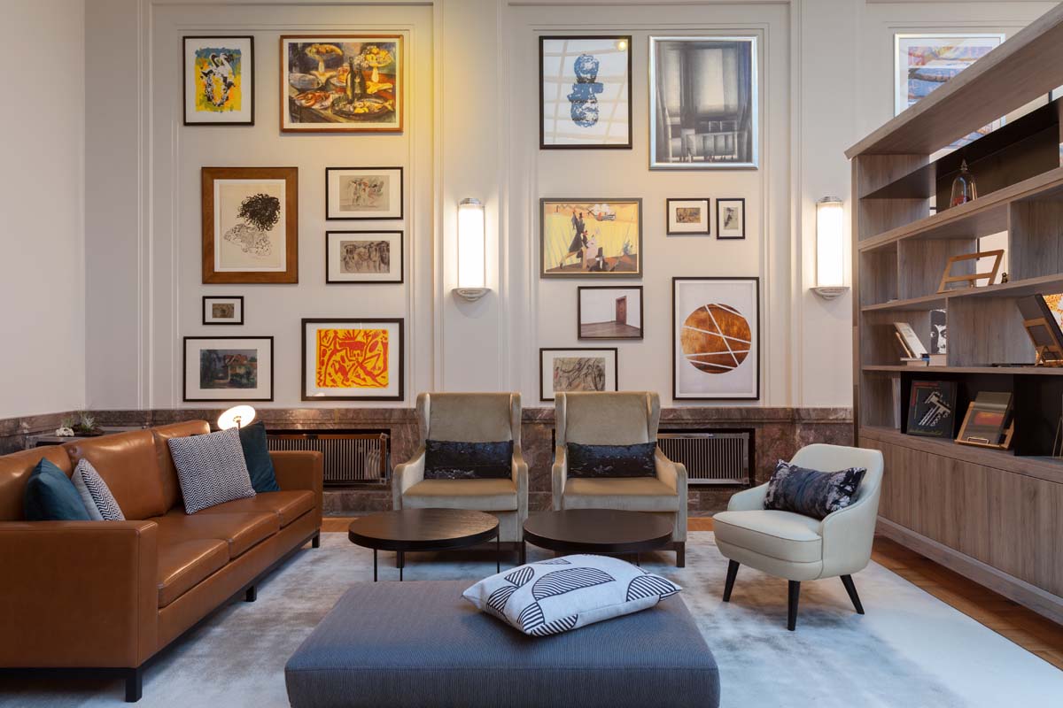 Modern seating area in the light room of the Hotel Elephant with cozy armchairs and works of art on the wall.